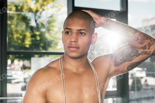 Preview: portrait of muscular african american sportsman with tattooed hand at gym