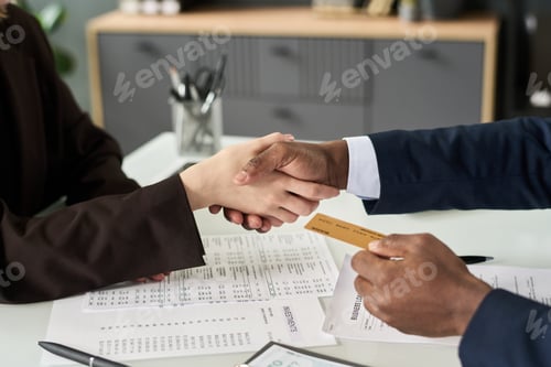Preview: Business People Shaking Hands To Conclude Financial Contract