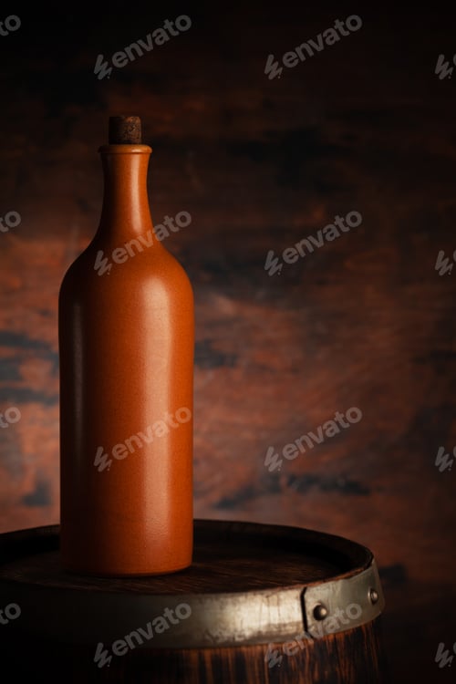 Preview: Red wine bottle on old wooden barrel