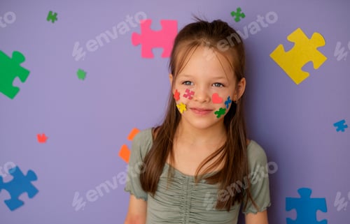 Preview: A girl with an autism spectrum disorder on violet background decorated with large multicolor puzzles