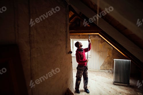 Preview: Man measuring a window during a home renovation