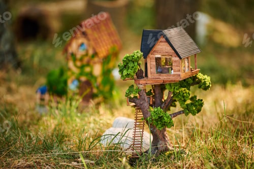 Preview: Little dollhouse on front lawn, cute small decorative house on green grass field, copy space