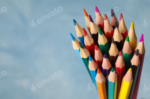 Preview: Multicolored pencils against light blue background, closeup