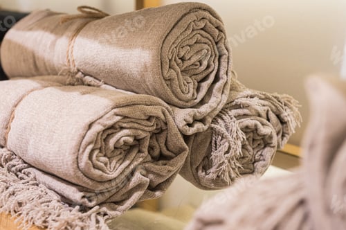 Preview: Rolled Beige Textured Throws on Wooden Shelf