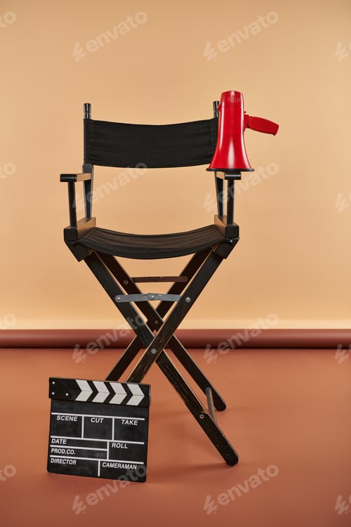 Preview: director chair stands tall, adorned with a megaphone and clapper board, cinematography concept