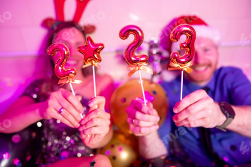 Preview: Couple holding numbers 2023 at New Year party