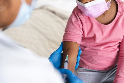 Preview: African american female doctor wearing face mask vaccinating girl patient at hospital