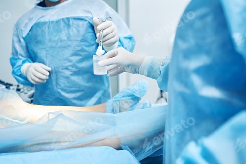Preview: Medical Personnel Perform Procedure in Blue Surgical Garb