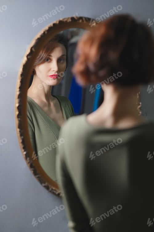 Preview: Portrait of confident stylish lady looking to the wall mirror