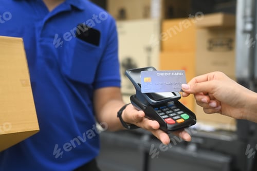 Preview: Delivery man delivering a package to a customer and receiving payment with credit card