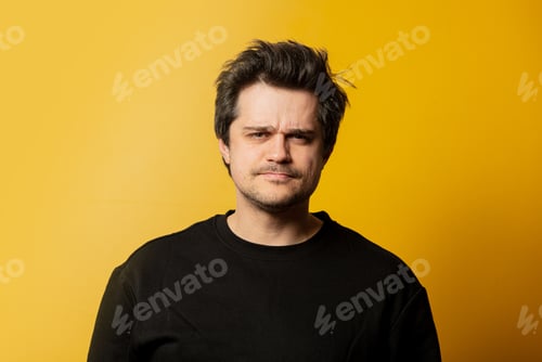 Preview: Surprised white guy in black shirt on yellow background
