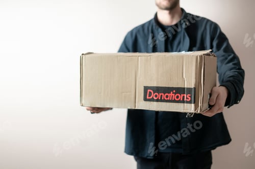 Preview: a person holding a cardboard box with a donation word, charity volunteer delivery