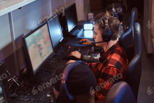 Preview: Team of teenage gamers plays in a multiplayer video game on pc in a gaming club.