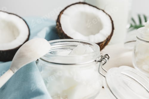 Preview: Organic healthy coconut butter and fresh coconut pieces on wooden board