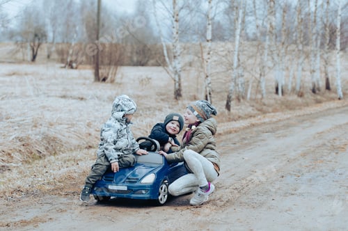Preview: Three happy children having fun playing with a toy car