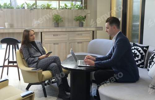 Preview: two attractive young people having a business meeting in a modern cafe.