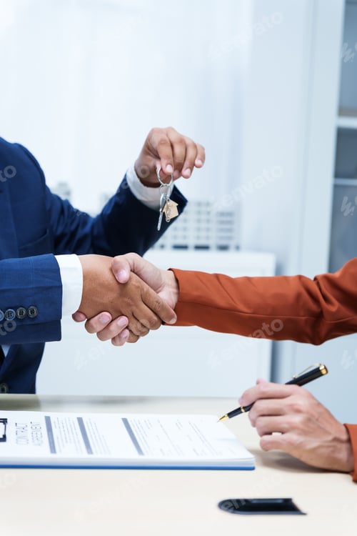 Preview: A businessman desk in a sales office sells a condo building customer.They agree to sign a contract