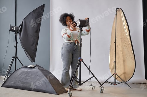 Preview: Black Woman Setting Up Lighting Equipment