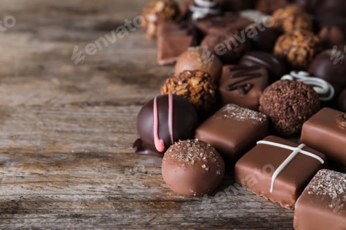 Preview: Different delicious chocolate candies on wooden table