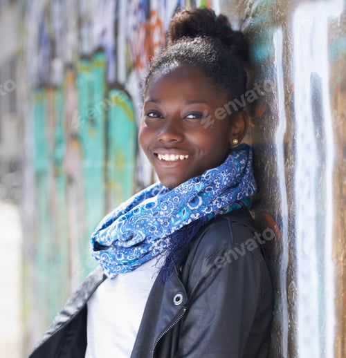 Preview: Ready for her future. Portrait of a beautiful young woman leaning against a wall in the city.