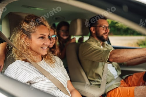 Preview: Mother on passenger seat enjoying road trip and traveling by car with her family