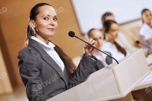 Preview: Businesswoman Standing On Stage And Reporting For Audience