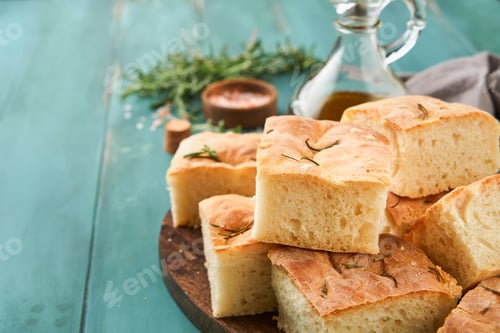 Preview: Focaccia. Italian traditional bread and pastry recipe cut into pieces for serving with olive oil, ar