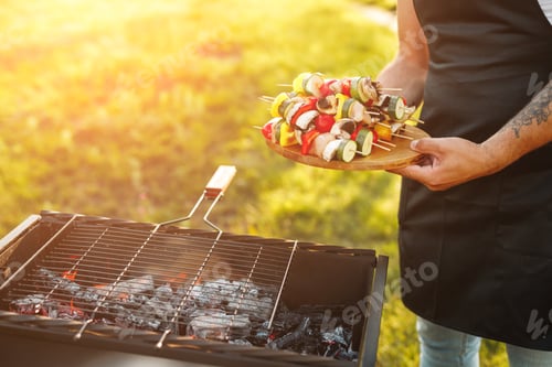 Preview: Crop chef with shashlik near grill with charcoal