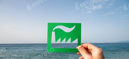 Preview: Hand holding green industry over sea