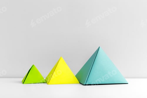Preview: Colorful paper pyramids in a row on a simple background showcase fun geometry and design