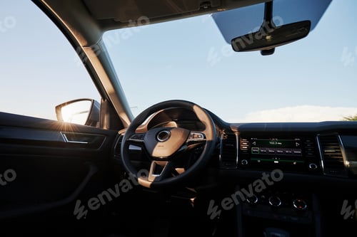 Preview: Beautiful sun beam in mirror. Inside modern car. Front panel, steering wheel, quality material