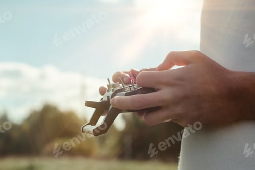 Preview: Drone quadrocopter controls off from man hands outdoors