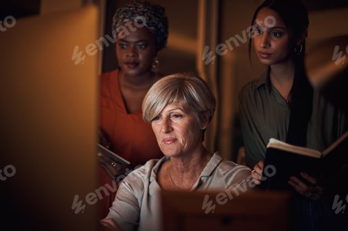 Preview: Shot of a group of businesswomen working together on a computer in an office at night