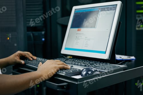 Preview: Cropped shot of an IT technician using a computer while working in a data center