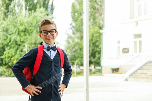 Preview: Boy with backpack against school building, space for text