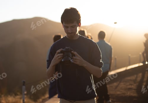 Preview: Man holding camera on hill