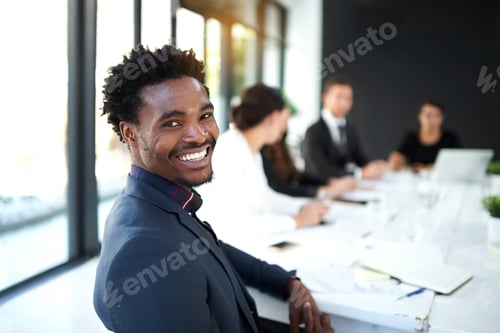Preview: Portrait of a businessman sitting in a boardroom meeting with colleagues in the background
