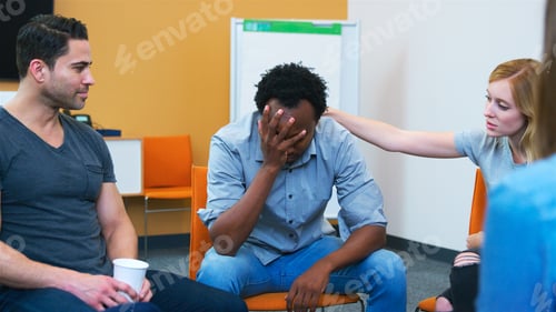 Preview: Multi-Cultural Group Of Men And Women Offering Support At Mental Health Group Therapy Meeting