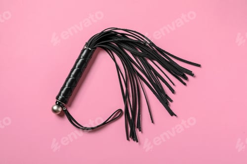 Preview: Black whip on pink background, top view. Sexual role play accessory