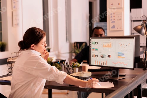 Preview: Company analyst analyzing marketing report diagrams on computer screen
