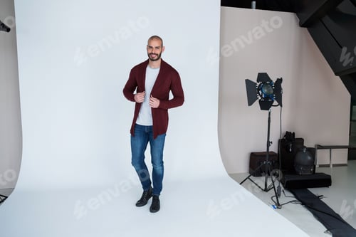 Studio is featuring white cyclorama with overhead softbox, spotlight, sandbags, cables, cases