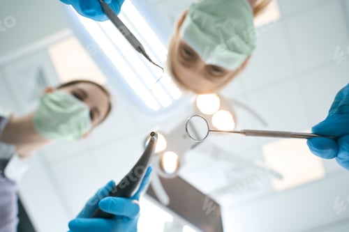 Preview: Assistant and dentist cleaning teeth from plaque