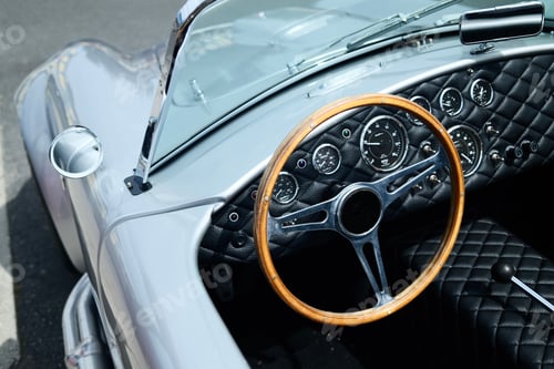 Preview: Close-up view of a vintage car interior with a wooden steering wheel and classic dashboard.