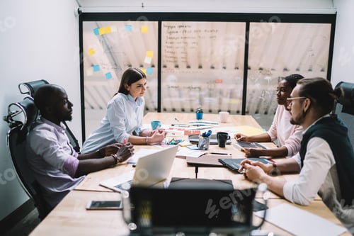 Preview: Thoughtful multiracial coworkers making decision during conference in office