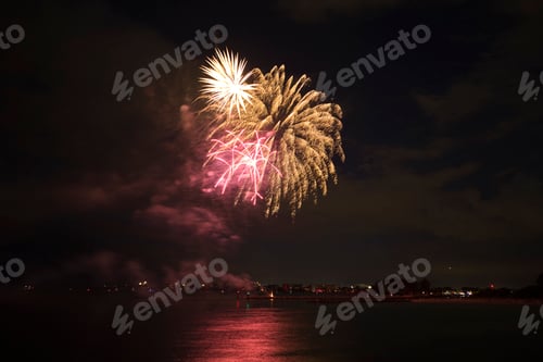 Visualização: Vista aérea de fogos de artifício brilhantes explodindo com luzes coloridas sobre a costa do mar