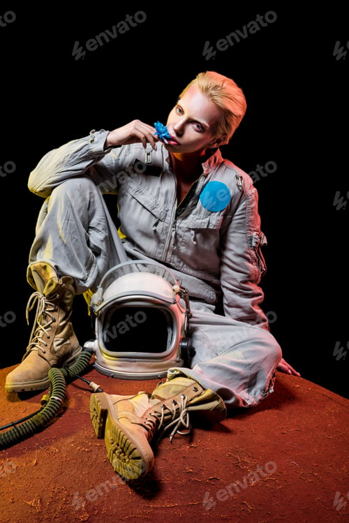 Preview: beautiful astronaut in spacesuit with flower and helmet sitting on planet