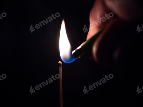 Preview: Selective focus shot of a person lighting up a match stick in the darkness