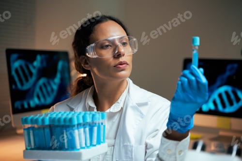 Preview: Female scientist holding test tube analyzing DNA data