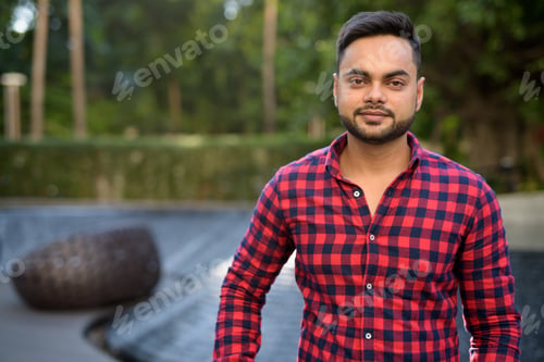 Preview: Young bearded Indian businessman relaxing at the mall in Bangkok