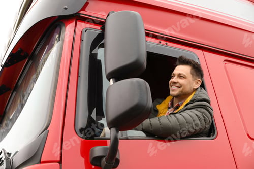 Preview: Portrait of happy driver in cab of modern truck